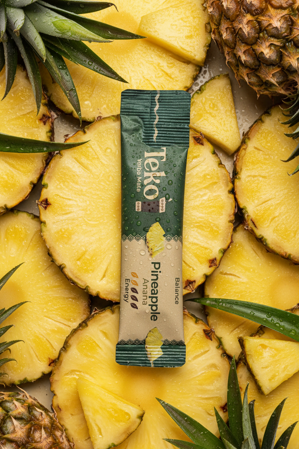 Teko pineapple flavor packet surrounded by sliced pineapples